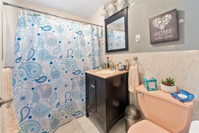 full bathroom featuring toilet, vanity, tile patterned flooring, and tile walls