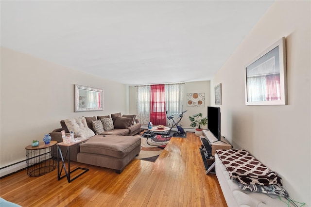 living room with a healthy amount of sunlight, wood-type flooring, and baseboard heating