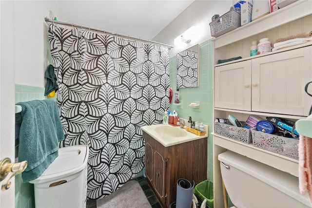 full bathroom with toilet, tile walls, and vanity