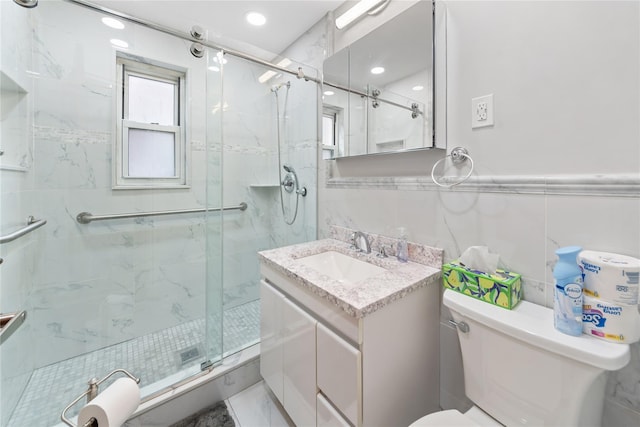 full bath with a marble finish shower, tile walls, toilet, and vanity