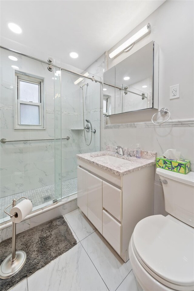 full bath featuring toilet, marble finish floor, a marble finish shower, and vanity