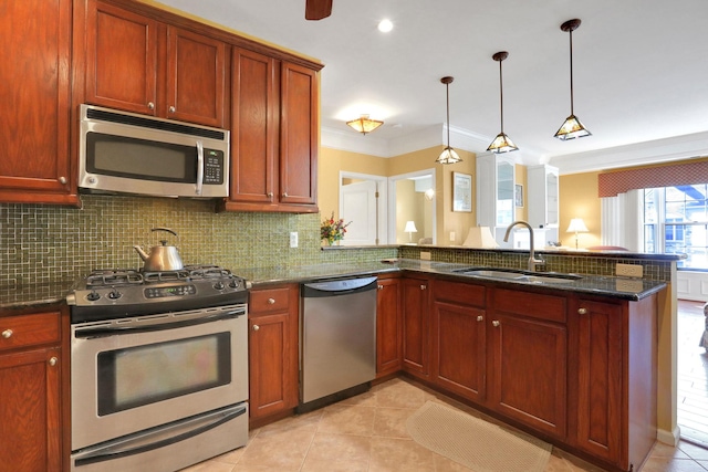 kitchen with dark stone countertops, a peninsula, a sink, stainless steel appliances, and backsplash