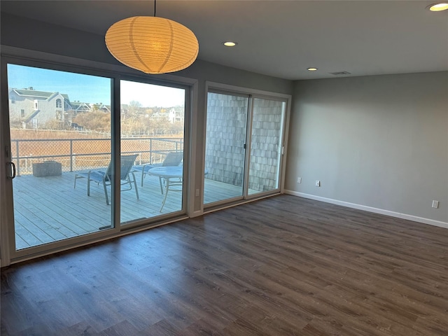 spare room with dark wood-style floors, recessed lighting, visible vents, and baseboards