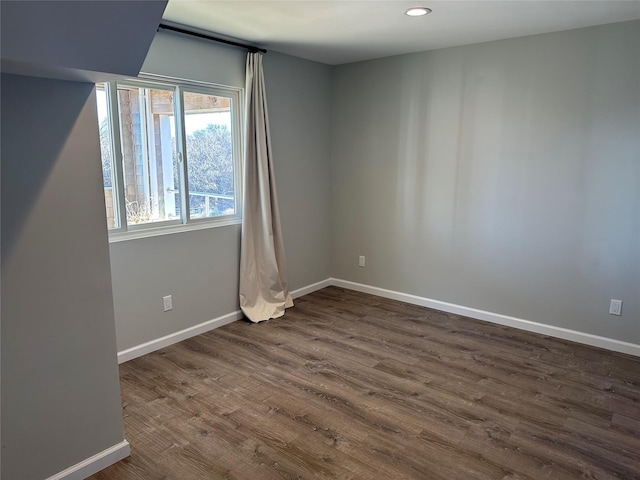 spare room featuring dark wood-style floors, baseboards, and recessed lighting