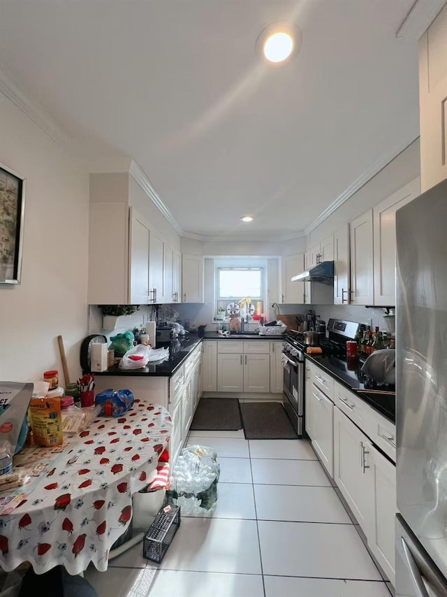 kitchen featuring light tile patterned floors, stainless steel appliances, white cabinetry, and under cabinet range hood