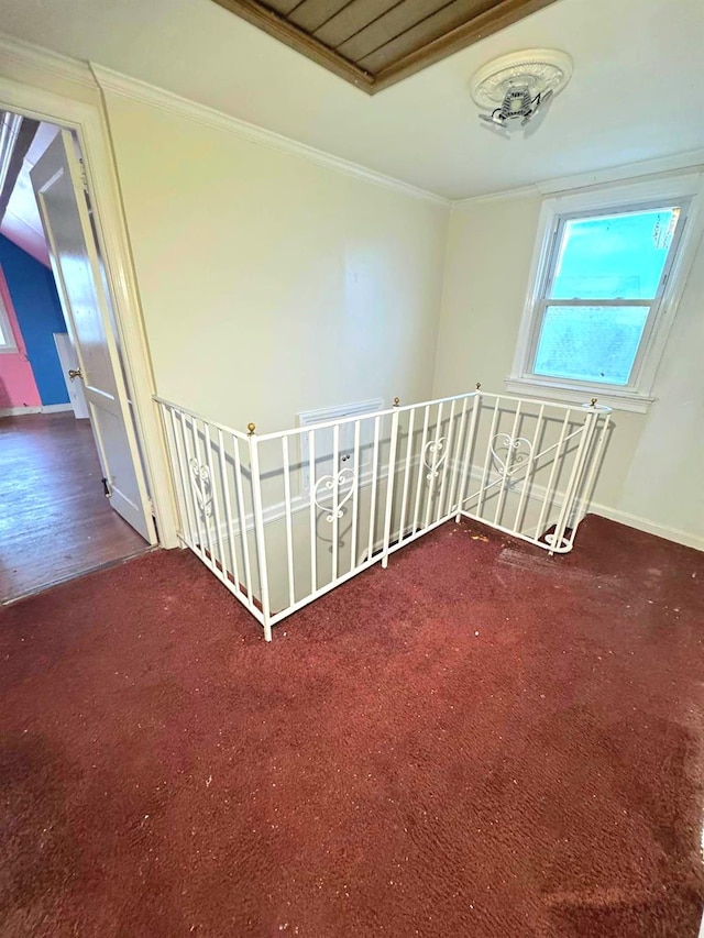 carpeted spare room with ornamental molding and baseboards