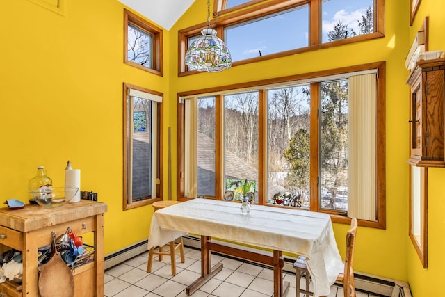 dining room featuring a baseboard radiator, light tile patterned floors, baseboards, and high vaulted ceiling