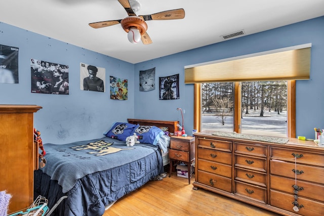 bedroom with light wood-type flooring, visible vents, and a ceiling fan