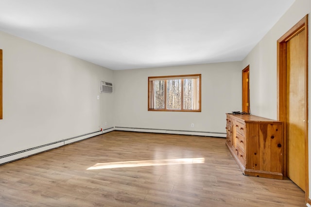 unfurnished room with a baseboard heating unit, a baseboard radiator, and light wood finished floors
