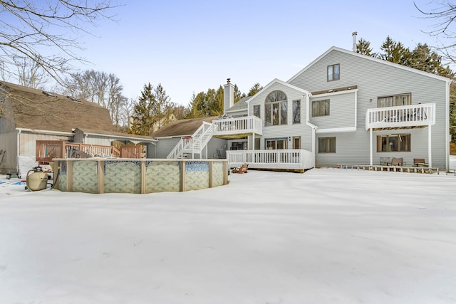 back of property featuring a chimney, stairway, and a deck