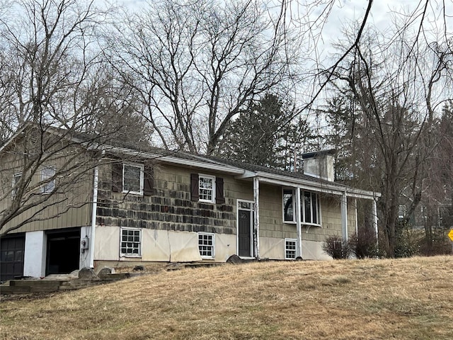 view of front of property with an attached garage, a chimney, and a front yard