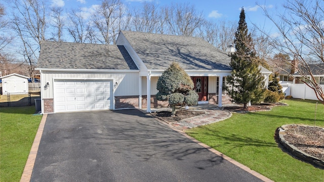 view of front of home with a garage, a front yard, fence, and driveway