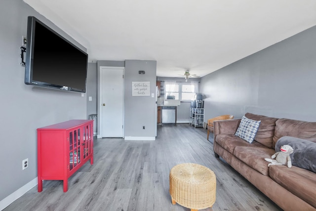 living area with ceiling fan, wood finished floors, and baseboards