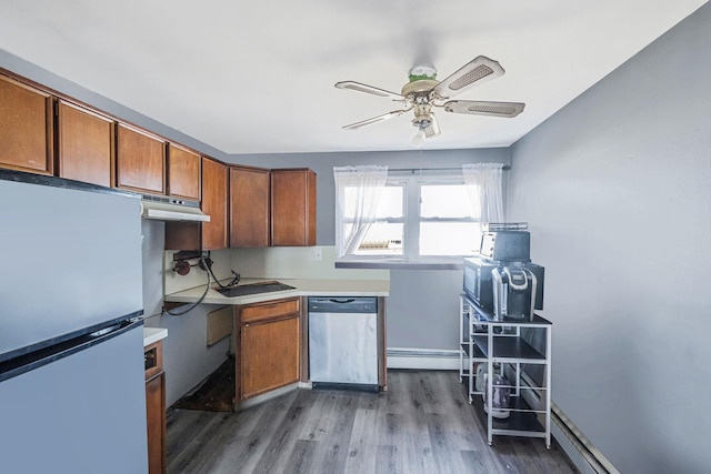 kitchen featuring dark wood finished floors, brown cabinets, stainless steel appliances, light countertops, and under cabinet range hood