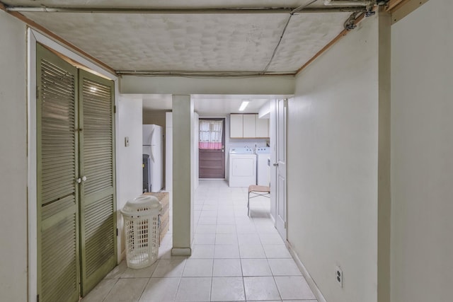 hallway featuring light tile patterned floors and separate washer and dryer