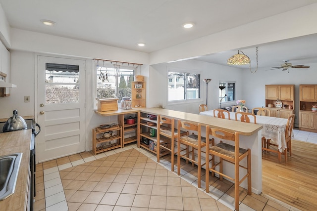 dining area featuring light tile patterned floors, a ceiling fan, and recessed lighting