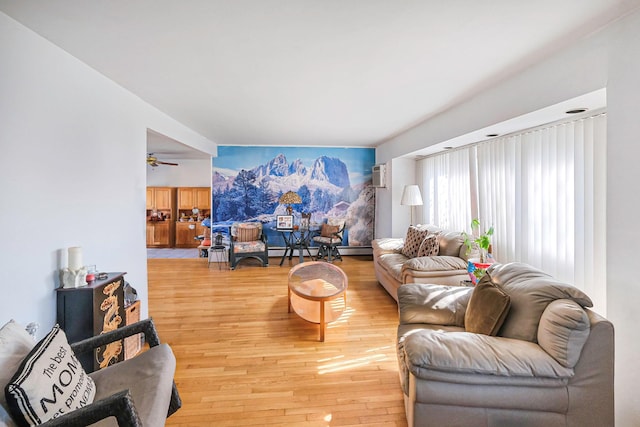 living area featuring a baseboard heating unit, wood finished floors, and an AC wall unit