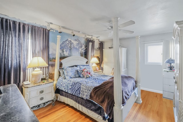 bedroom with light wood finished floors, ceiling fan, and baseboards