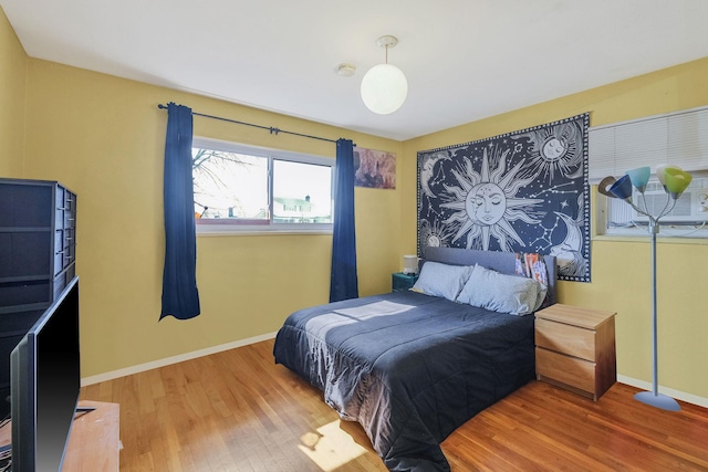 bedroom featuring baseboards and wood finished floors