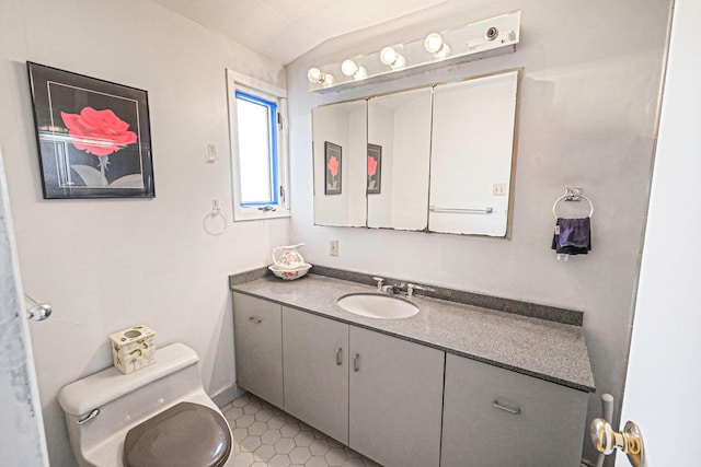 half bath featuring vaulted ceiling, toilet, tile patterned flooring, and vanity