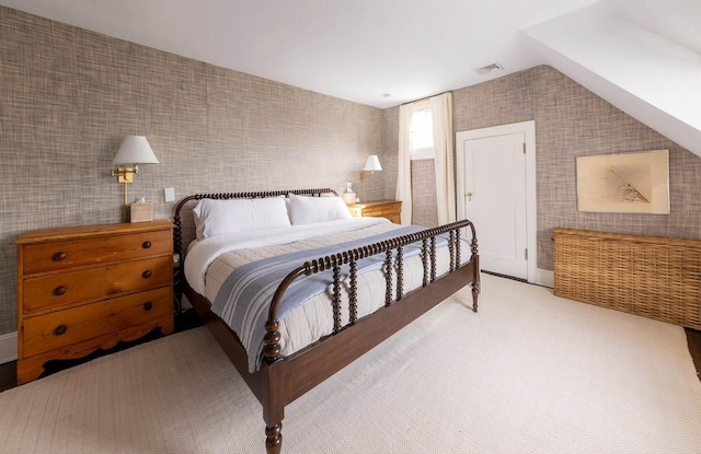 bedroom with vaulted ceiling, light carpet, visible vents, and wallpapered walls