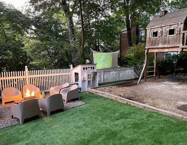 view of play area with a lawn, an outdoor structure, and fence