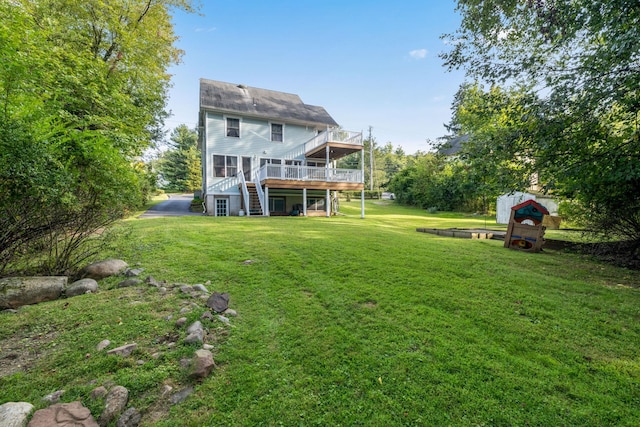 back of house with a deck, a yard, and stairway