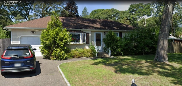 view of front of house featuring a garage, a front lawn, and aphalt driveway