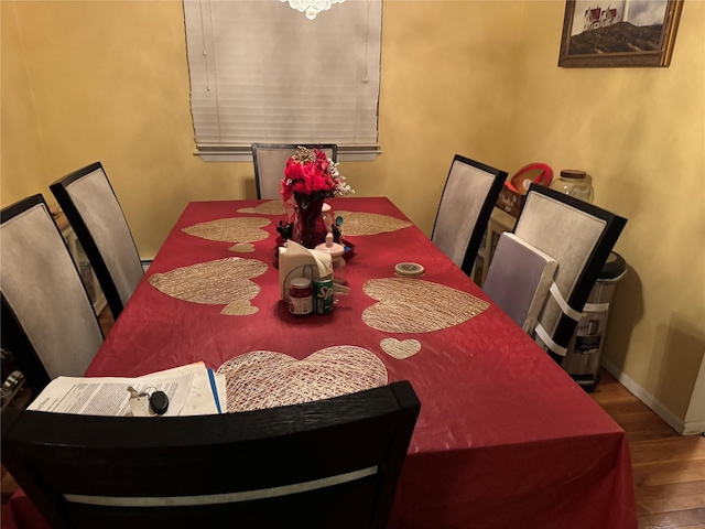 dining area with baseboards and wood finished floors