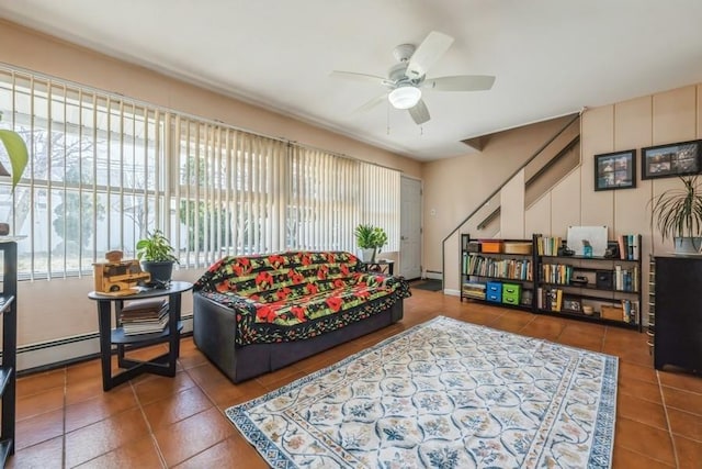 living room featuring ceiling fan, a baseboard heating unit, and tile patterned flooring