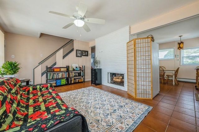 tiled living room with a large fireplace, ceiling fan, and baseboard heating