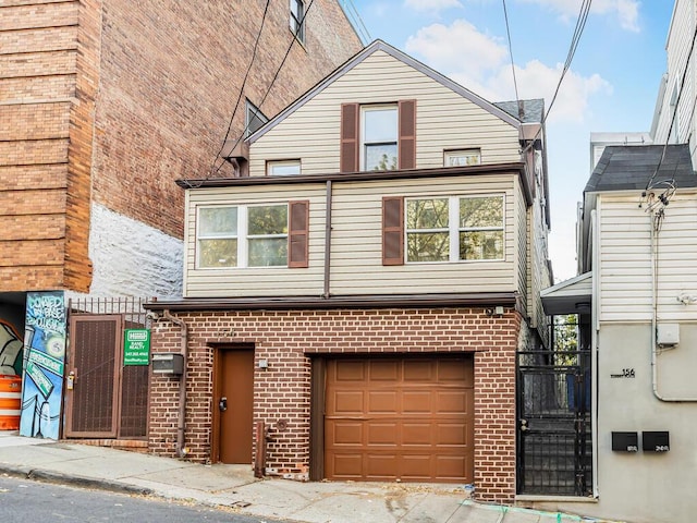 view of front facade with a wall mounted air conditioner, brick siding, and an attached garage