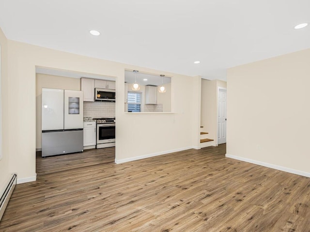 unfurnished living room with a baseboard radiator, recessed lighting, stairway, wood finished floors, and baseboards