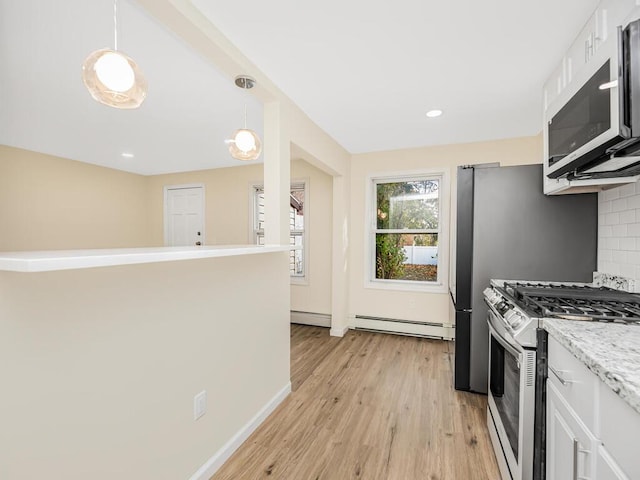 kitchen featuring pendant lighting, decorative backsplash, stainless steel range with gas stovetop, and white cabinets