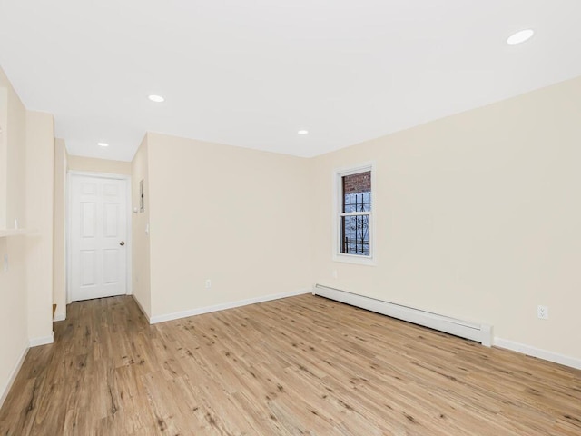 empty room featuring recessed lighting, baseboard heating, light wood-type flooring, and baseboards