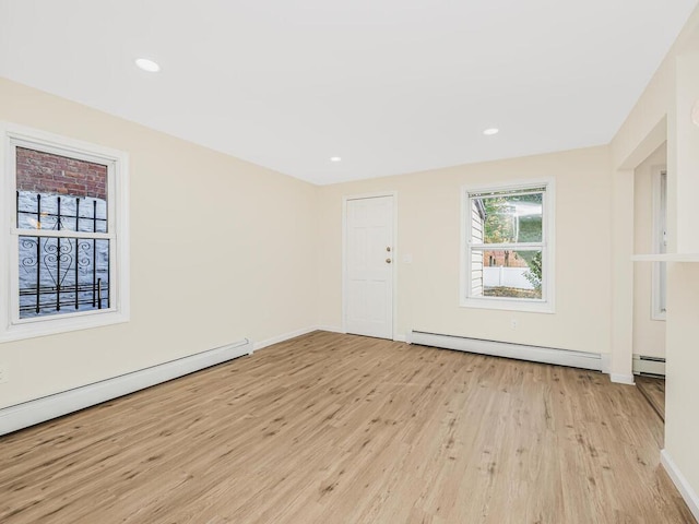 unfurnished room featuring a baseboard heating unit, recessed lighting, baseboard heating, and light wood finished floors