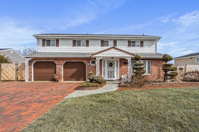 traditional home featuring a front yard, fence, decorative driveway, and brick siding