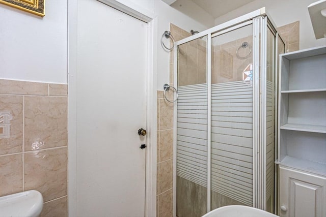 bathroom featuring a shower stall, toilet, and tile walls