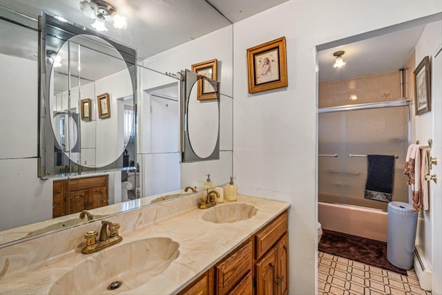 full bathroom with toilet, a baseboard radiator, double vanity, and a sink