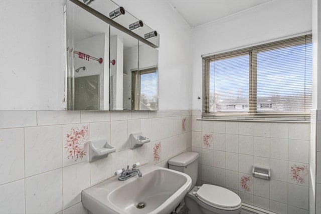 bathroom featuring toilet, walk in shower, a sink, and a wealth of natural light