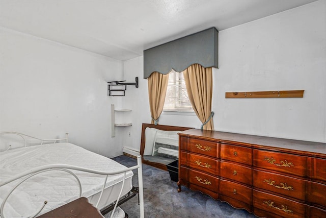 bedroom with baseboard heating and dark colored carpet