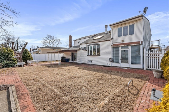 back of house with a chimney, a patio area, and fence