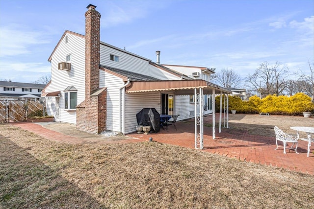 back of property with a patio area, a chimney, and fence