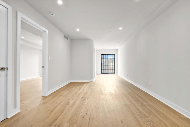 empty room featuring light wood-style floors, baseboards, visible vents, and recessed lighting