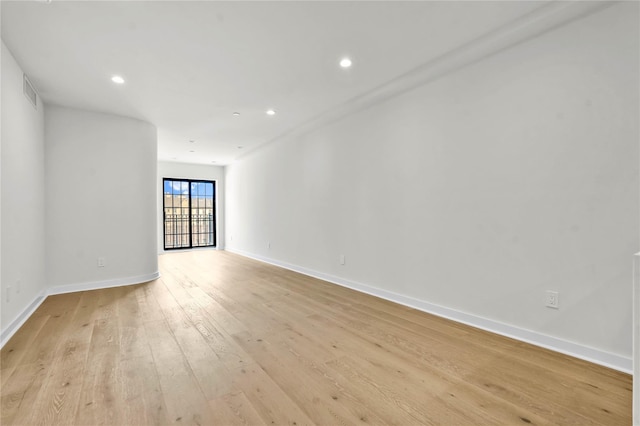 spare room featuring light wood-type flooring, visible vents, baseboards, and recessed lighting