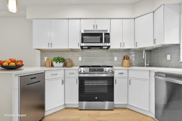 kitchen featuring a sink, stainless steel appliances, light countertops, and white cabinets