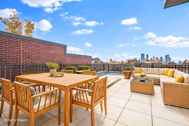 view of patio featuring outdoor dining space, a city view, and an outdoor hangout area