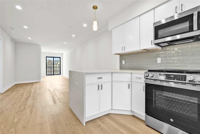 kitchen featuring open floor plan, backsplash, light wood-style floors, white cabinets, and appliances with stainless steel finishes