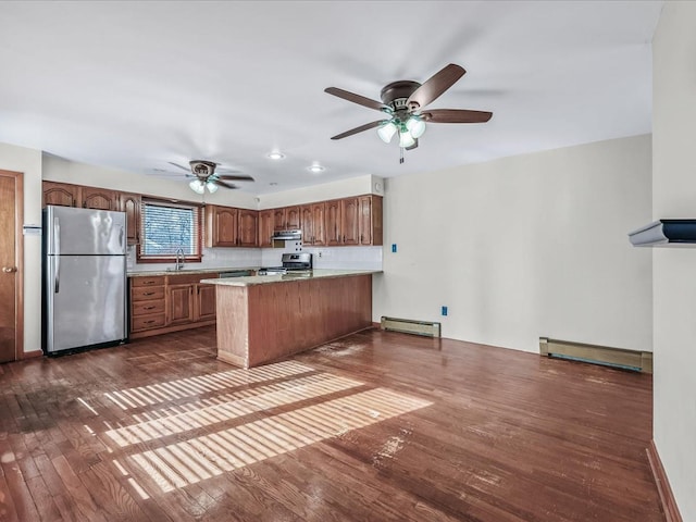 kitchen with stainless steel appliances, dark wood-type flooring, under cabinet range hood, and baseboard heating