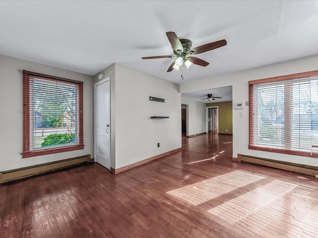 spare room featuring a healthy amount of sunlight, wood-type flooring, and baseboard heating